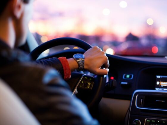 man driving a car wearing wrist watch