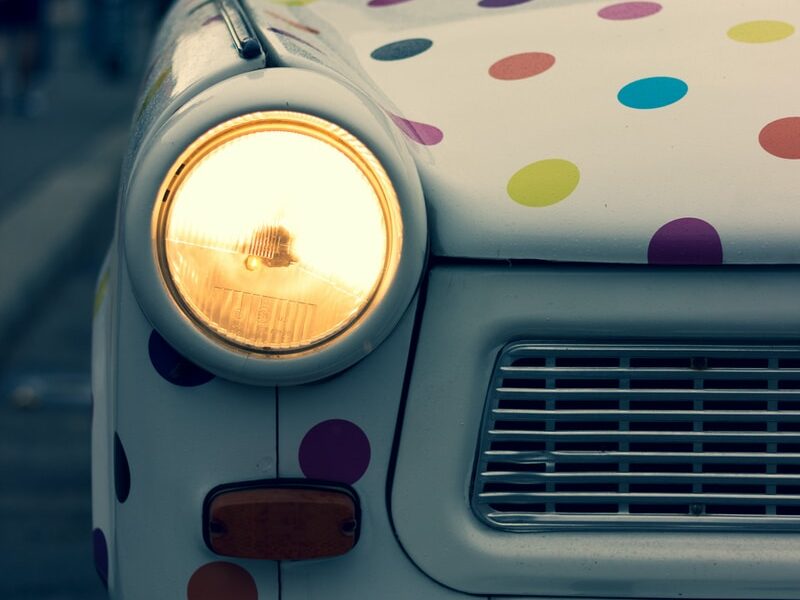 white and multicolored polka-dot vehicle with turned on headlight