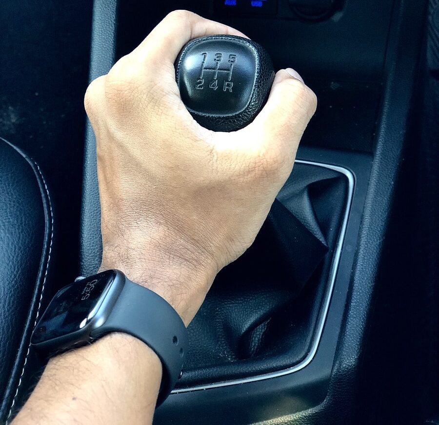 person holding black car gear shift lever