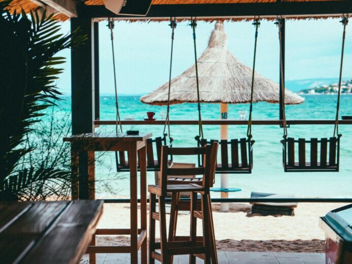 brown wooden beach lounge chair on beach during daytime