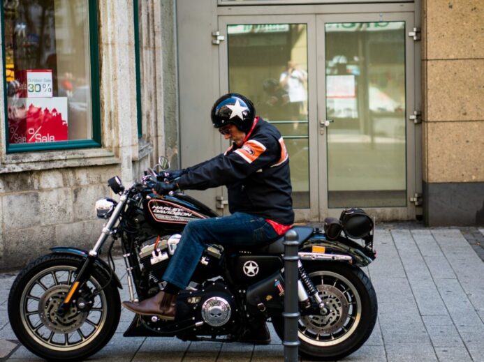 man riding black cruiser motorcycle