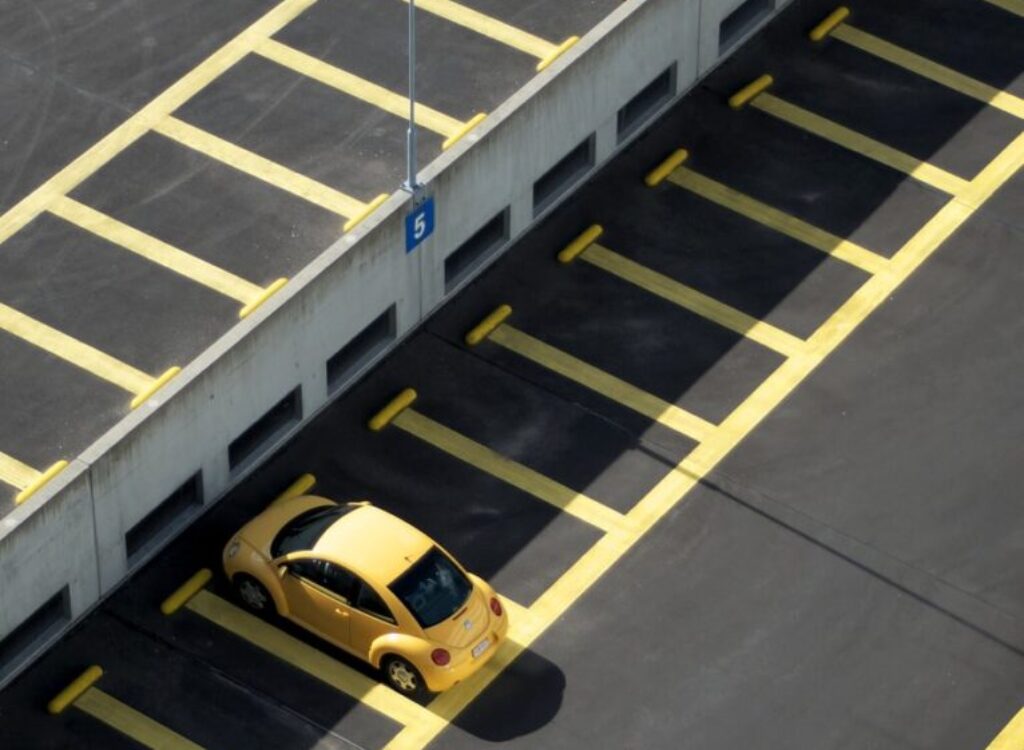 yellow coupe on parking lot at daytime