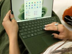 a woman using a laptop computer on a bed