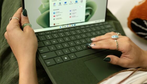 a woman using a laptop computer on a bed