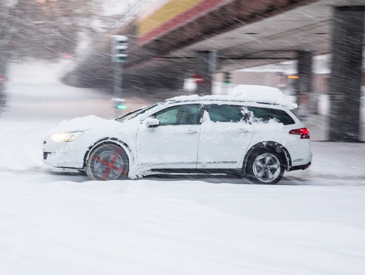 white sedan on snow covered road during daytime