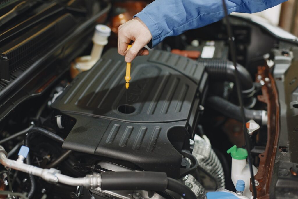 Person Checking the Oil of an Engine