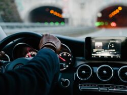 person inside vehicle holding steering wheel