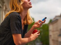 a woman holding a cup and a cell phone