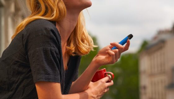 a woman holding a cup and a cell phone
