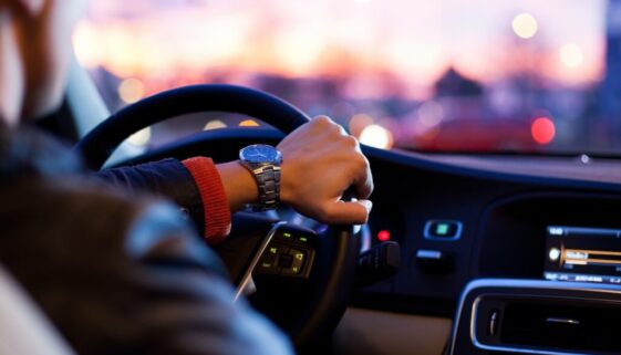 man driving a car wearing wrist watch