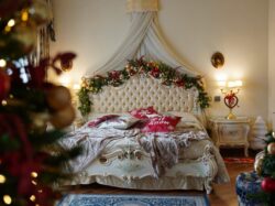 a bedroom decorated for christmas with a bed and a christmas tree