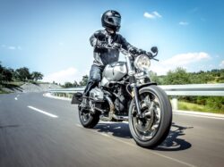 man in black helmet riding on black motorcycle on road during daytime