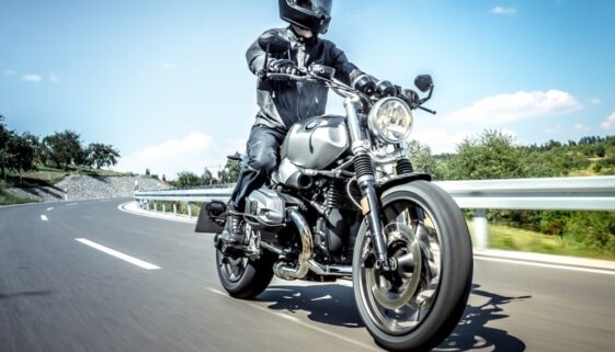 man in black helmet riding on black motorcycle on road during daytime