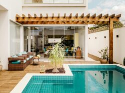 brown wooden table near swimming pool