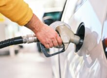 a man pumping gas into his car at a gas station