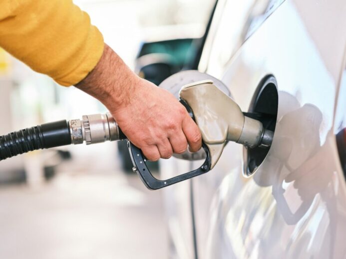 a man pumping gas into his car at a gas station