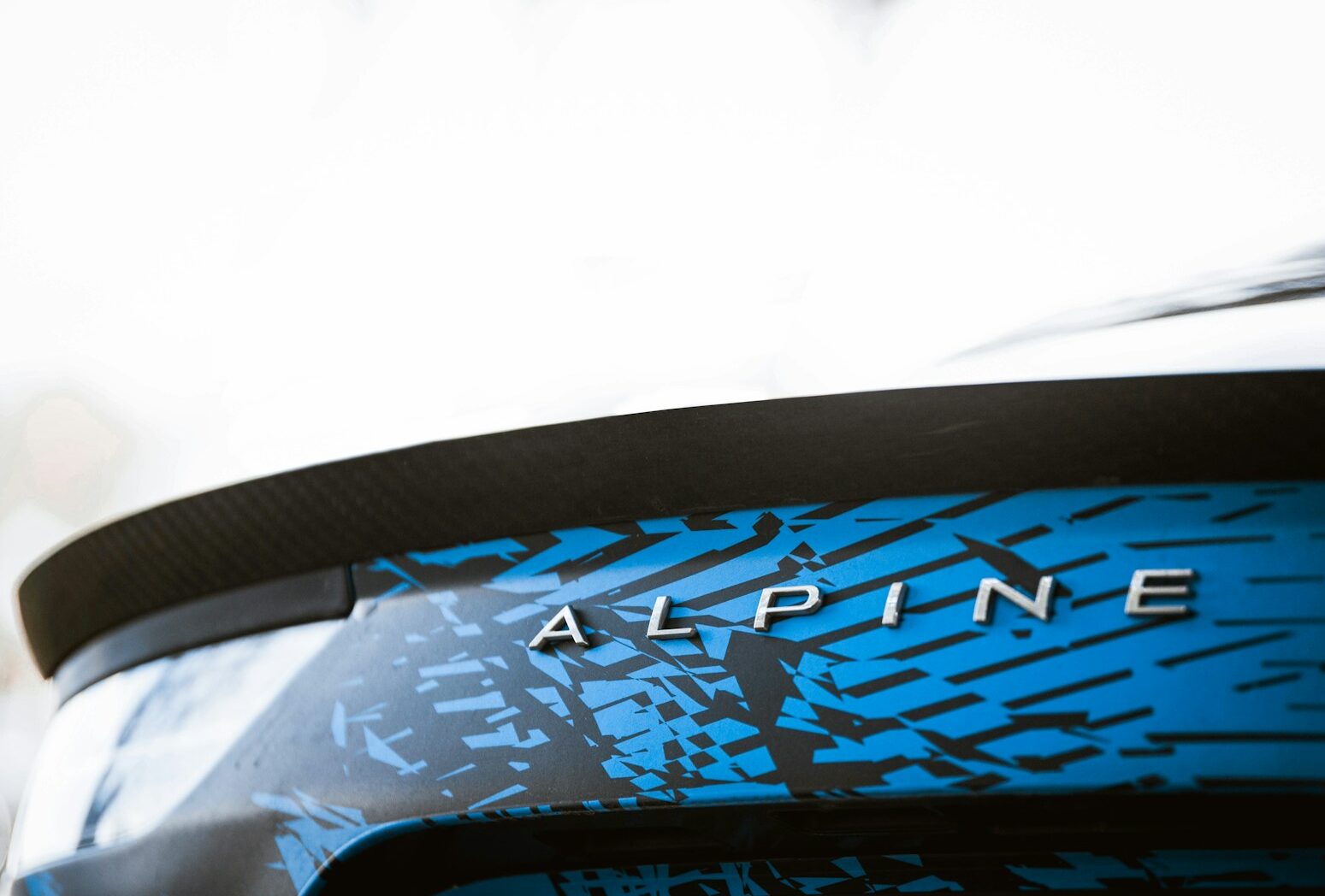 a close up of a blue and black car with the word alpine on it