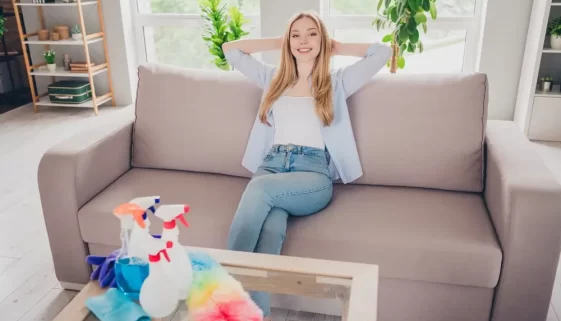 žena sedí před stolkem s čistícími prostředky