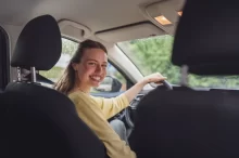 žena jede v autě a směje se