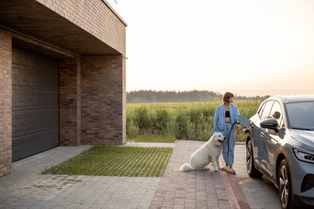 žena nabíjí elektromobil na zahradě