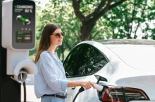 Žena nabíjející elektrické auto.