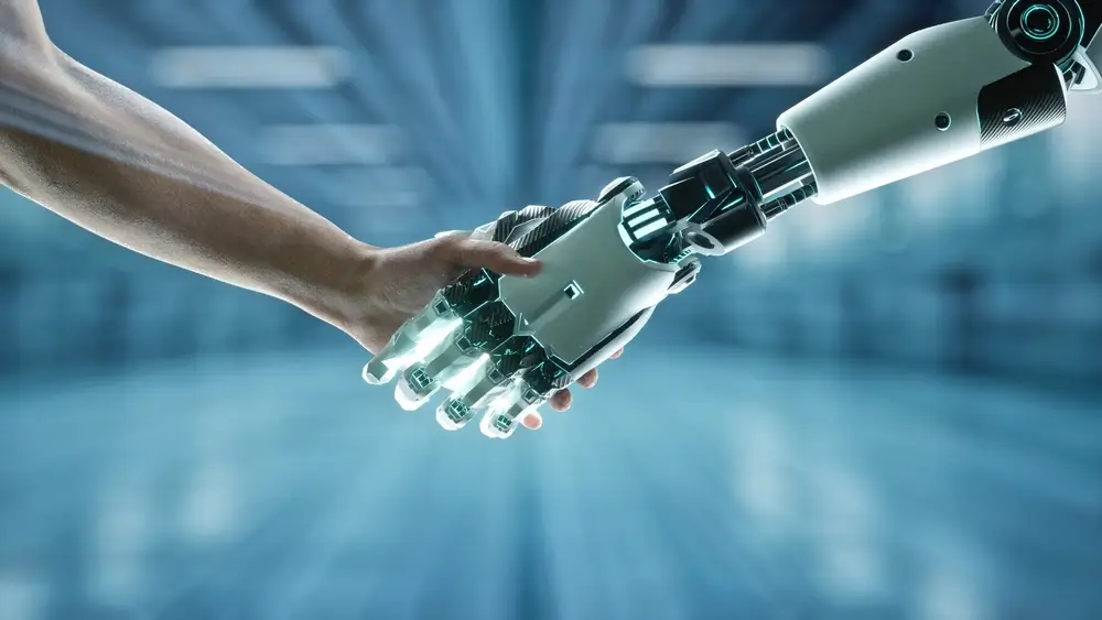 robot a člověk se drží za ruce