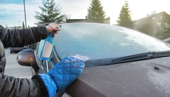 muž stříká roztok na auto