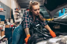 žena opravuje motor auta
