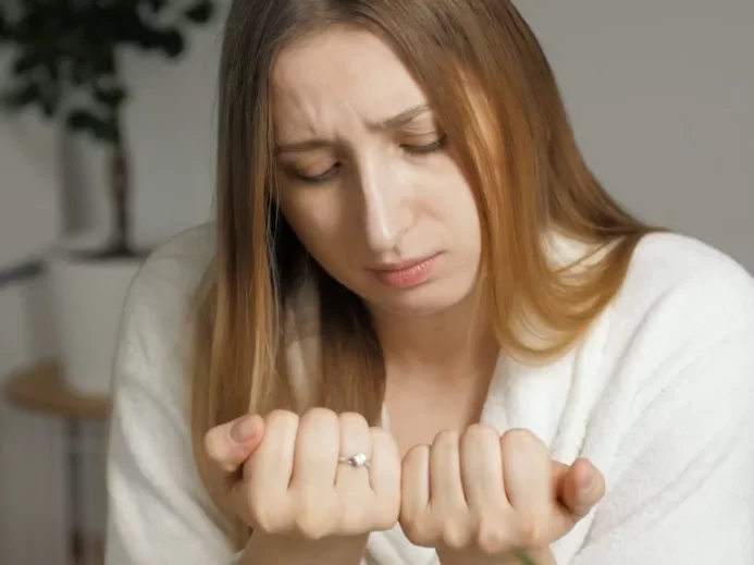 žena sleduje své nehty