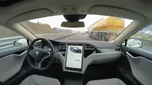 Interiér autonomního auta při jízdě po vozovce.