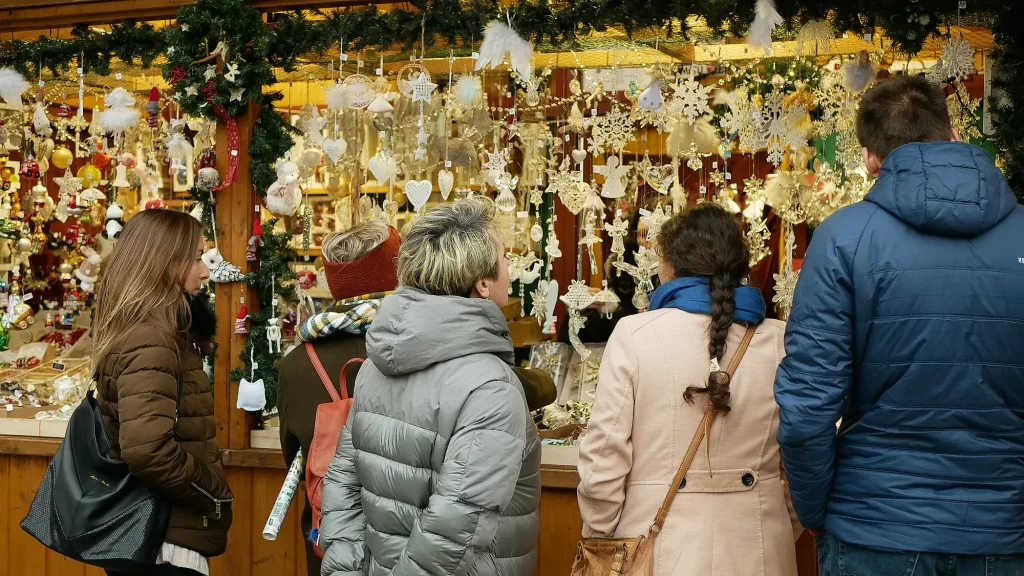 Lidé si prohlíží nabídku adventních trhů.