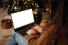 Žena s notebookem u Vánočního stromečku.