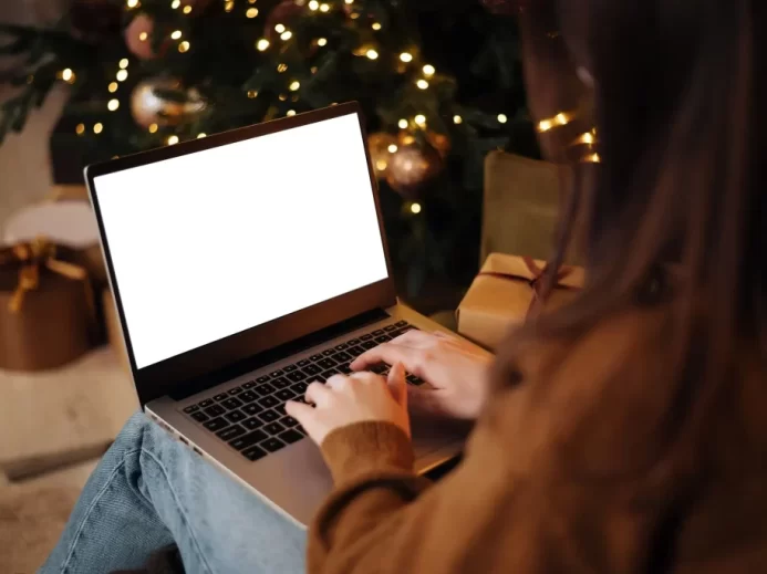 Žena s notebookem u Vánočního stromečku.