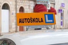 česká značka autoškoly na autě, které projíždí městem