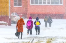 děti jdou ve sněhu do školy