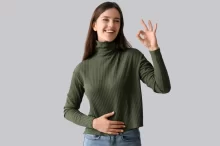 Spokojená žena držící se za břicho.