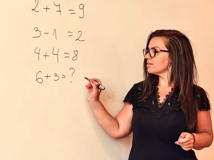 žena píše na tabuli matematické příklady z IQ testu