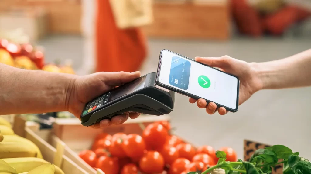 Platba pomocí telefonu v obchodě se zeleninou a ovocem.