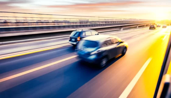 Auto jedoucí po dálnici při západu slunce, pohybová neostrost