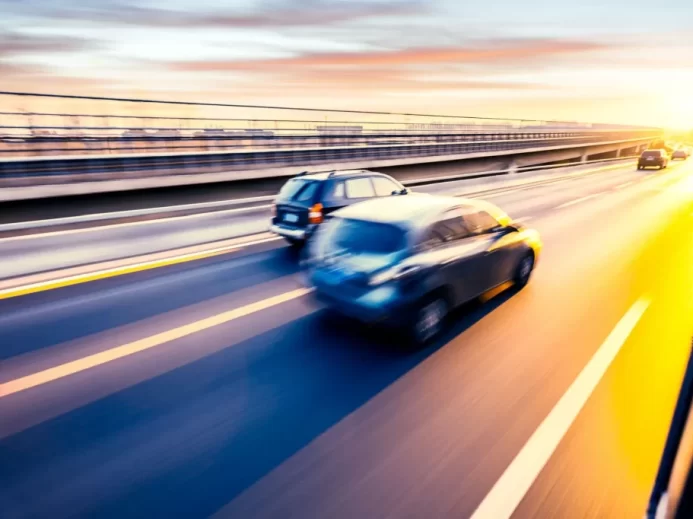 Auto jedoucí po dálnici při západu slunce, pohybová neostrost
