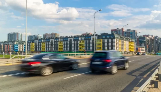 Jedno auto předjíždí druhé na ulici. Rozmazaný pohyb