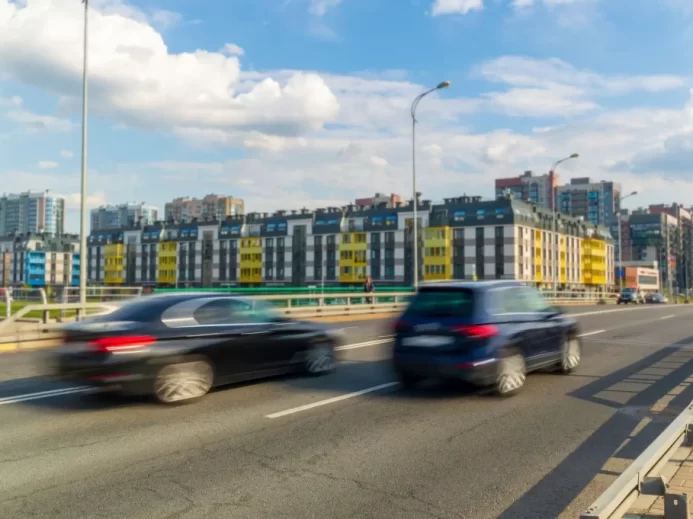 Jedno auto předjíždí druhé na ulici. Rozmazaný pohyb