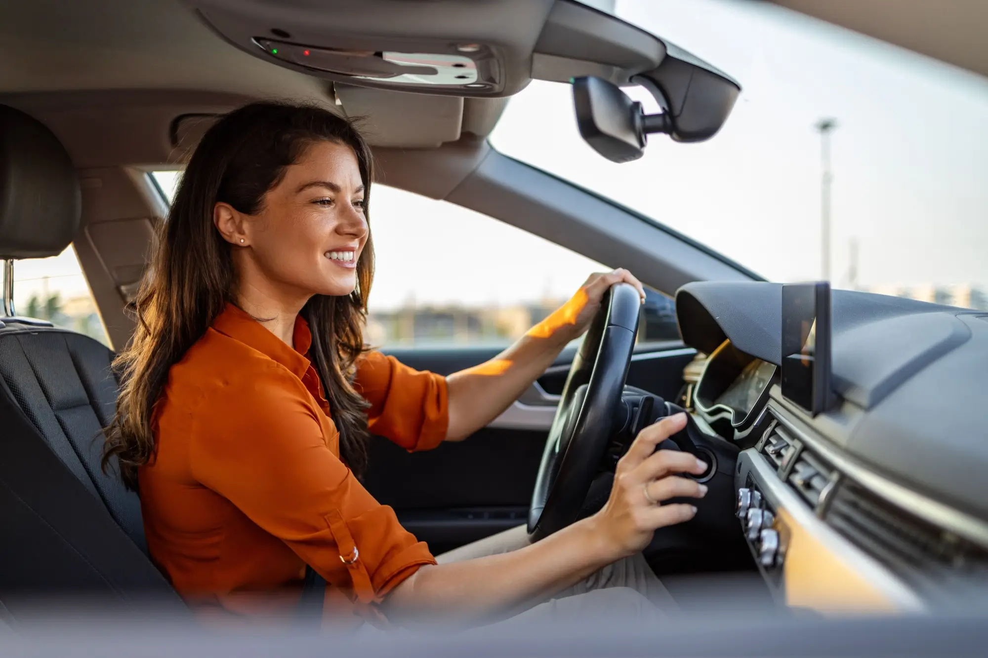 Shutterstock_2369419491 - MotorGuru.cz Mladá žena nastavující klimatizaci v autě.
