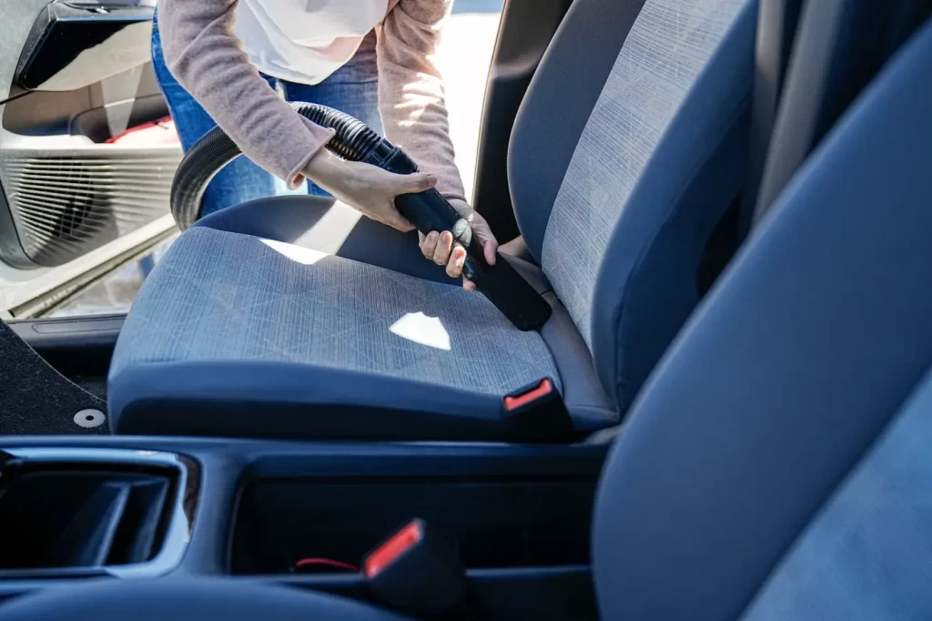 Žena vysává autosedačku.