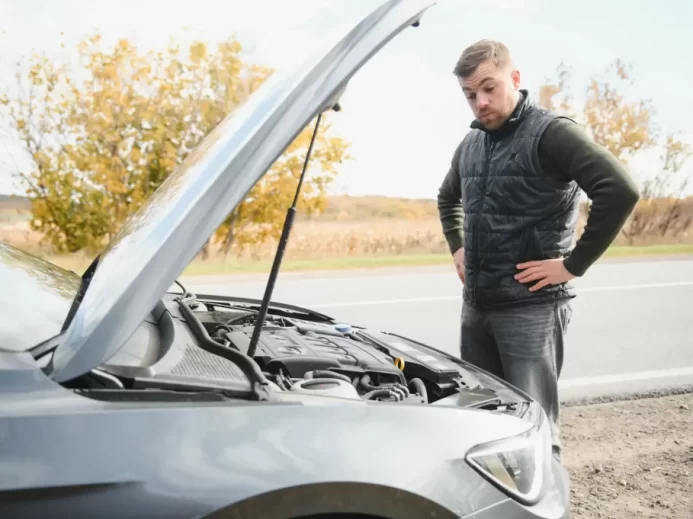 Muž u otevřené kapoty