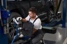 Muž u kola vozu, provádí diagnostiku