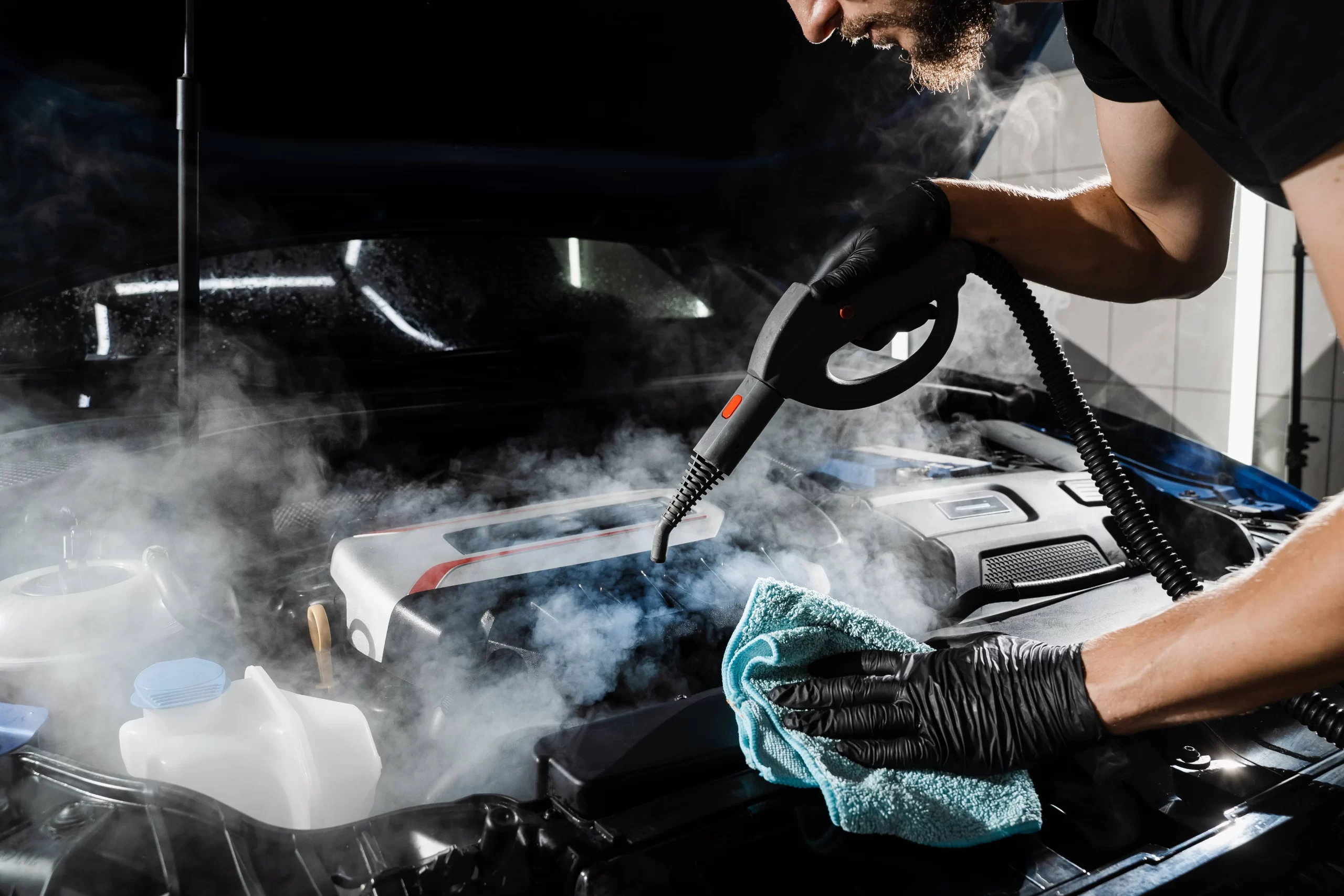 Muž čistí motor auta