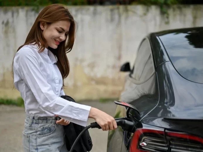Žena nabíjející svůj elektromobil Tesla