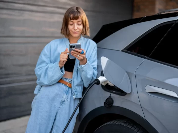 Žena čeká až se jí nabije auto