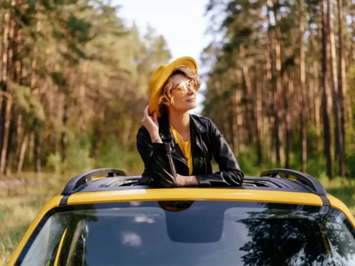 Žena ve střešním okně v autě